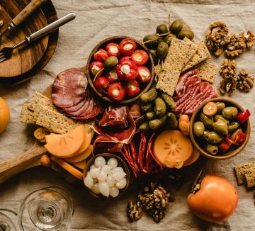 A beautifully arranged Mediterranean charcuterie board featuring meats, cheeses, olives, and nuts.